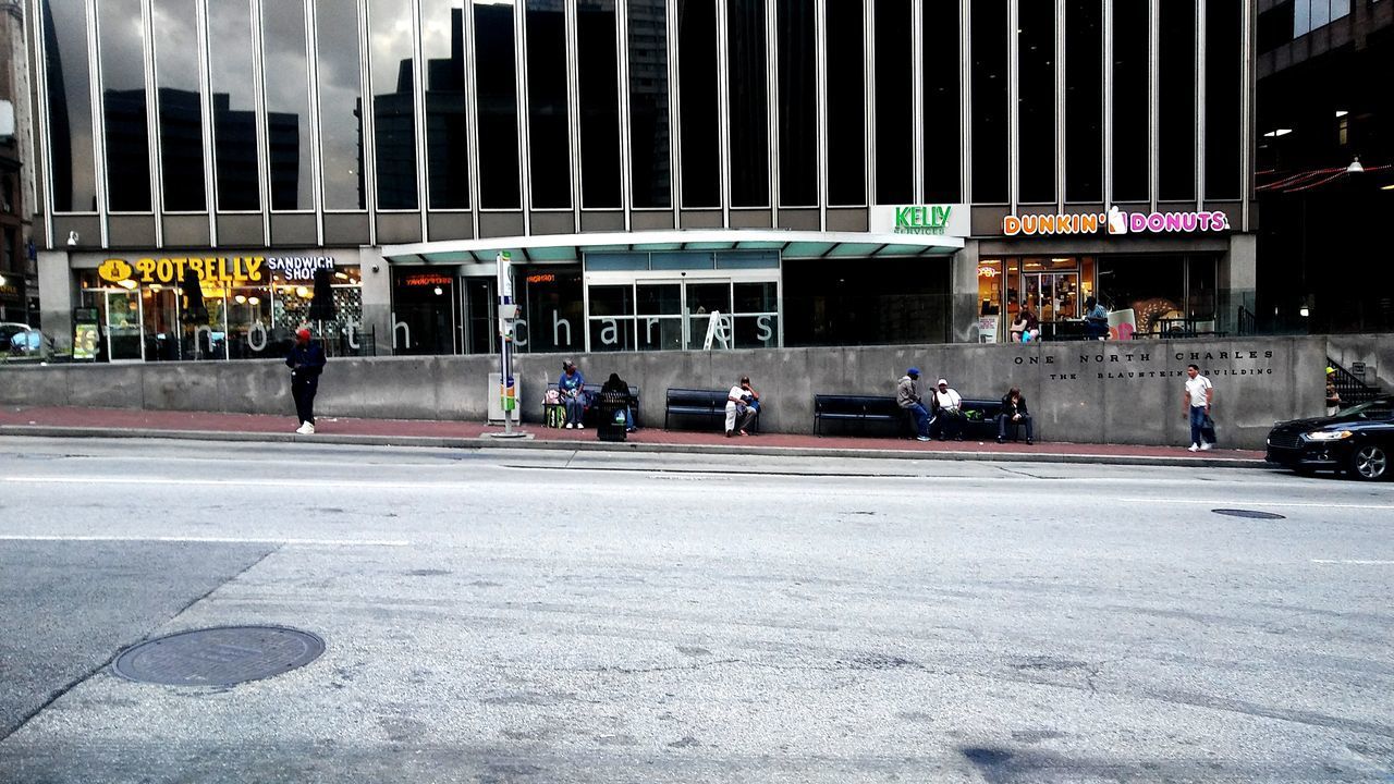 GROUP OF PEOPLE ON ROAD BY BUILDINGS IN CITY