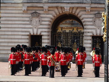 Marching band with musical instruments against buckingham palace 