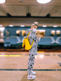 Midsection of woman standing by yellow umbrella