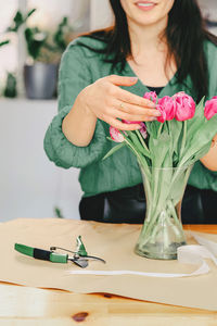 Midsection of woman holding plant