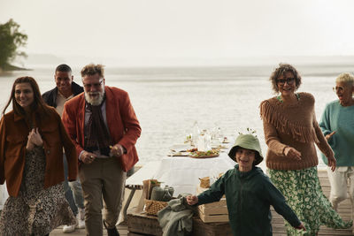 Family leaving dinner table by lake