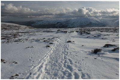 Scenic view of snow covered land against sky