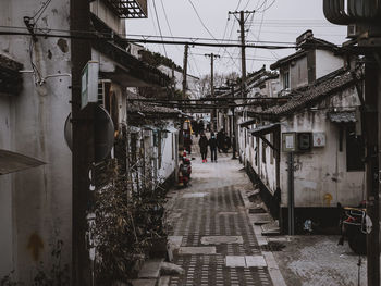 People walking on footpath amidst buildings in city