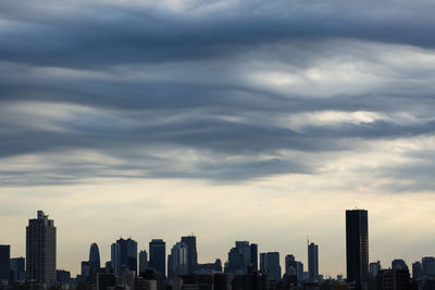 View of cityscape against cloudy sky