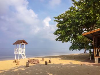 Lifeguard hut on beach against sky