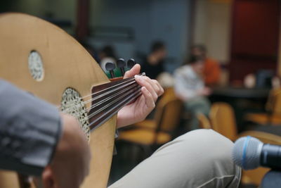 Midsection of man playing guitar