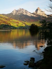 Scenic view of lake and mountains against sky. 