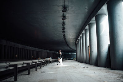 Rear view of woman walking on bridge in building