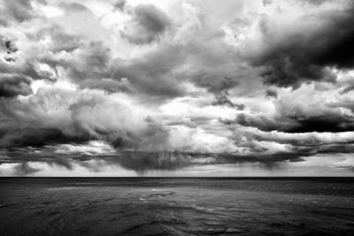 Scenic view of sea against storm clouds