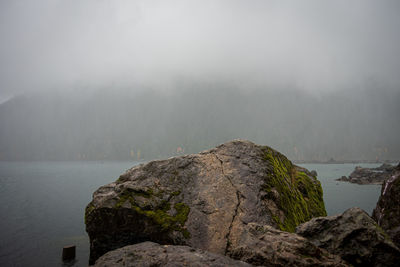 Scenic view of sea and mountains against sky
