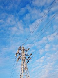 Low angle view of electricity pylon against cloudy sky