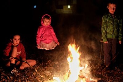 Children looking at campfire during camping