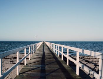 Pier on sea against clear sky