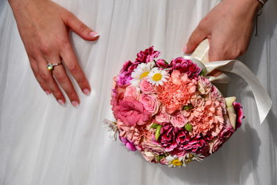 Midsection of bride holding flower bouquet