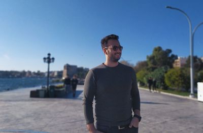 Portrait of young man standing against clear sky