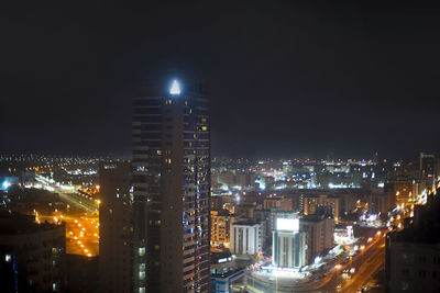 Illuminated buildings in city against sky at night