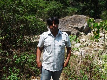 Portrait of young man standing in forest