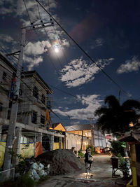 People on street amidst buildings against sky at dusk