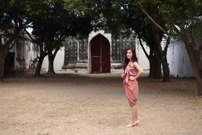 Portrait of woman standing against trees