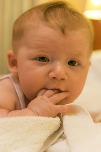 Close-up portrait of smiling baby lying on bed at home