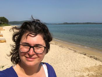 Portrait of woman at beach against sky