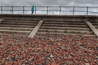 Rear view of person walking on staircase