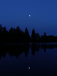 Scenic view of lake against sky at night