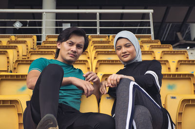 Portrait of young couple sitting on chair