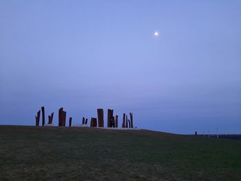 Rear view of woman standing on field against clear sky