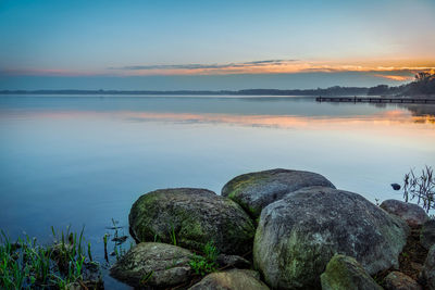 Scenic view of lake against sky at sunset