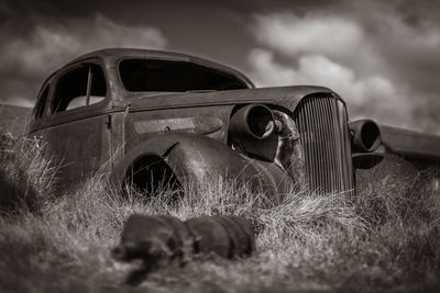 Old abandoned car on field