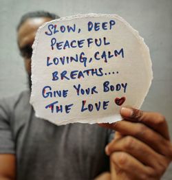 Man holding a quote written on paper 