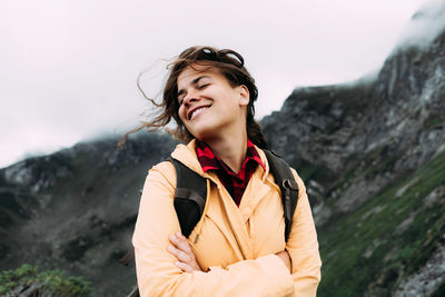 Young happy smiling woman with hair blowing in the wind.