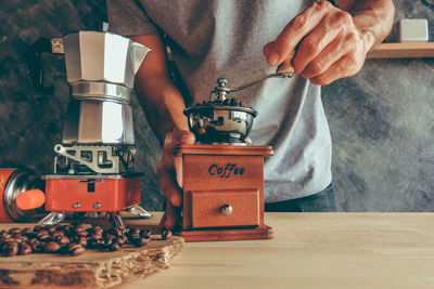 Midsection of man with coffee cup on table