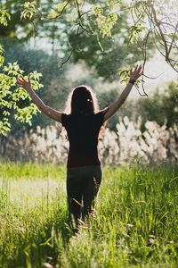 Rear view of woman standing in grass