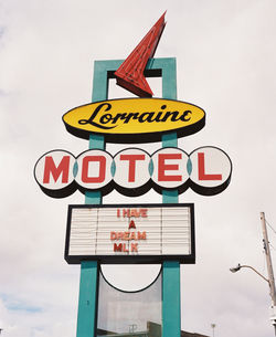 Low angle view of road sign against sky