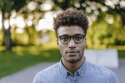 Portrait of young man wearing glasses in park