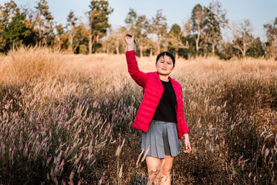 Portrait of smiling young woman standing on field