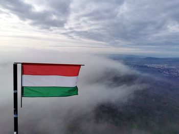 Scenic view of flag against cloudy sky