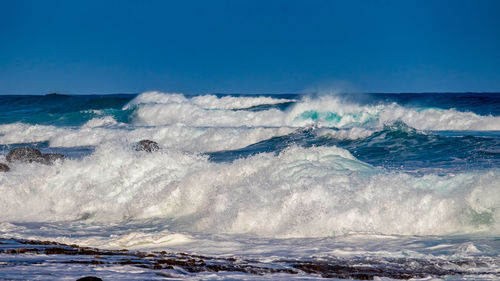 Scenic view of sea against clear blue sky