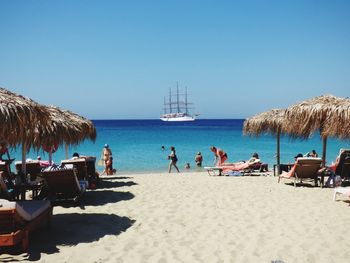 Panoramic view of people on beach against clear sky