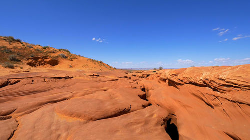 Scenic view of desert against blue sky