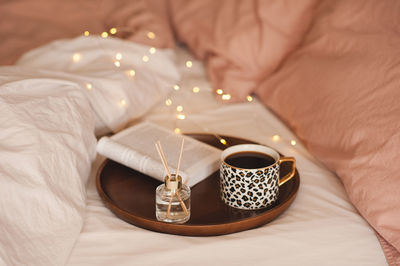 Close-up of coffee on tray with book and diffuser 