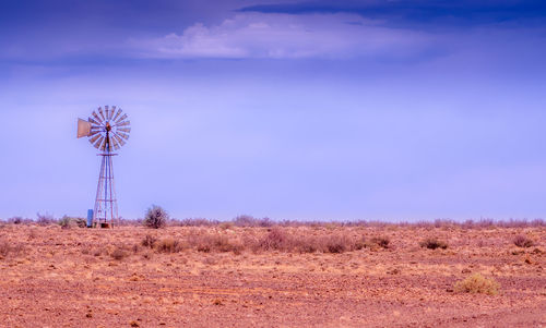 Traditional windmill on field against sky