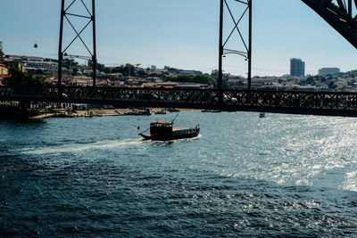 Boat sailing on sea against sky in city