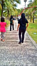 Full length of woman standing on footpath in park