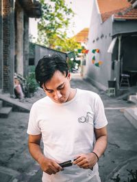 Young man looking at camera while standing on street