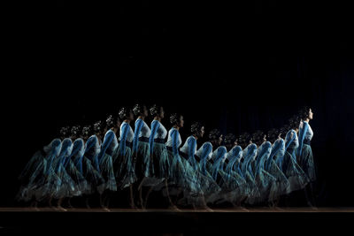 Multiple image of woman dancing against black background