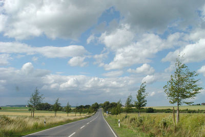 Road passing through landscape against sky