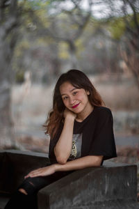 Portrait of a young woman sitting outdoors